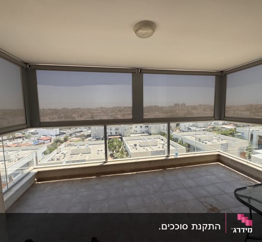 מרפסת עם סוככים חיצוניים נגללים על חלונות